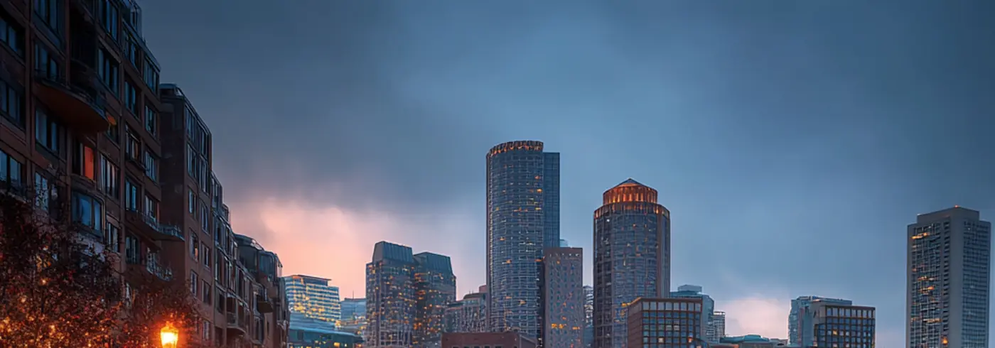 Boston Harbor cobblestone waterfront at dusk — orange lanterns reflecting on wet stone, skyline across the water